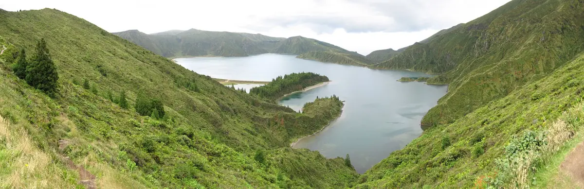 Crater lake seen from above between steep green slopes on São Miguel